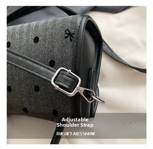 Detail of adjustable leather strap and silver buckle on herringbone bow handbag