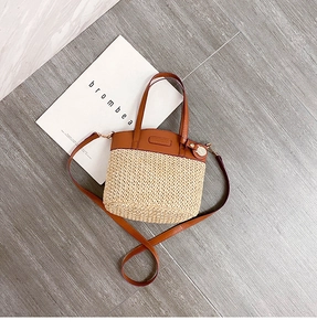 Vista dall'alto di una borsa a secchiello vintage con pelle marrone e paglia intrecciata