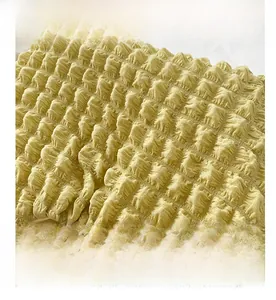 Macro shot of 3D textured bubble fabric details on a ginger yellow shoulder bucket bag