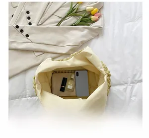 Internal view of cream pleated bucket bag showing capacity for phone and cosmetics