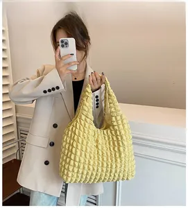 Detailed view of pale yellow pleated bubble texture fabric on a large tote bag