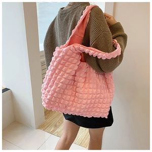 Detail of pink bubble texture fabric on a large capacity tote bag worn by a model