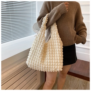 Close-up of white bubble texture tote bag with pleated fabric and wide handle detail