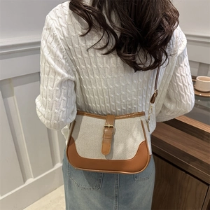 Retro canvas and brown leather shoulder bag shown on model wearing white knit sweater