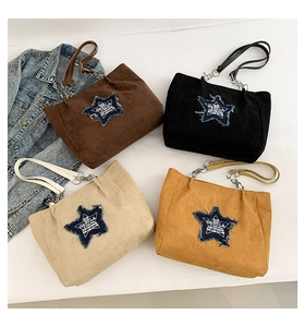 Flat lay of corduroy tote bags in four colors with star patches and chain handles