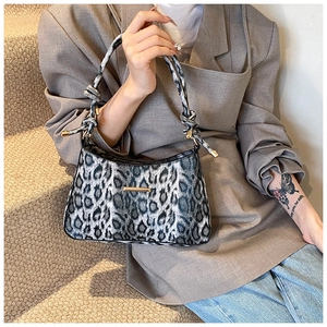 Dettaglio della borsa baguette leopardata con manico annodato e finiture dorate