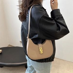 Minimalistische beige Halbmond-Umhängetasche mit goldener Schnalle an weiblichem Model