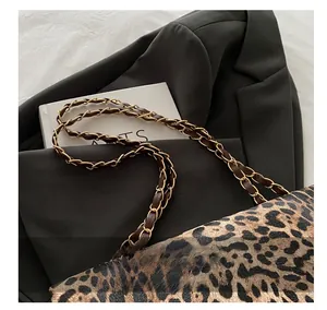 Detail of leopard print bag with gold metal chain and black leather woven shoulder strap