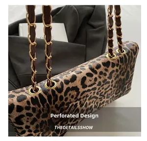 Detail of leopard print bag featuring metal grommets and brown leather woven chain strap