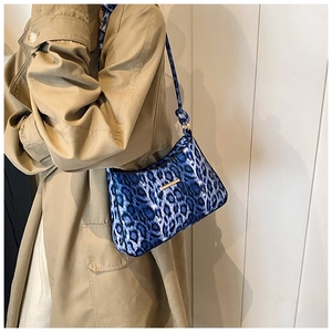Borsa a tracolla leopardata blu con dettagli dorati su trench color kaki elegante