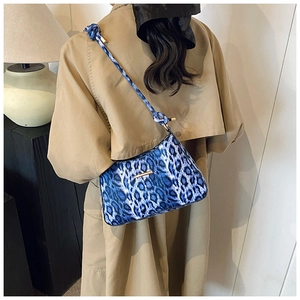 Borsa sottobraccio leopardata blu con tracolla a nodo indossata da una modella