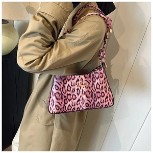 Dettaglio della borsa a spalla leopardata rosa con trama felpata e barra in metallo dorato