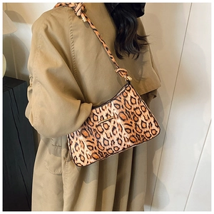 Dettaglio della borsa sottobraccio leopardata con tracolla annodata e barra dorata