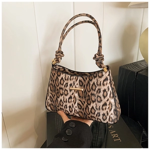 Dettaglio della borsa baguette leopardata con fibbia dorata e tracolla con nodo
