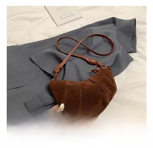 Detailed view of dark brown frosted suede dumpling bag with pleated organza folds and strap