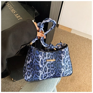 Dettaglio borsa a mano leopardata blu in ecopelliccia con manico a corda e barra dorata