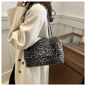 Detail of leopard print shoulder bag featuring metal chain strap and textured leather finish
