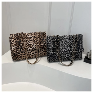 Detail showing two leopard print square clutch bags with gold chain and leather straps
