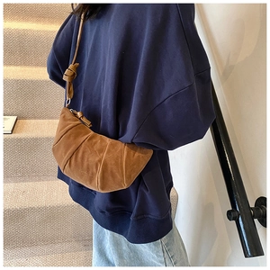 Detail of vintage brown suede croissant bag with pleated design and knot strap