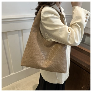Macro detail of the brown woven leather texture and elegant hobo shape of the shoulder bag