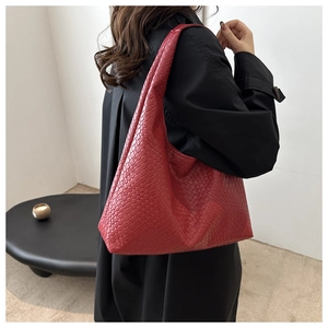 Close-up of red woven leather tote bag texture and soft oversized hobo style design