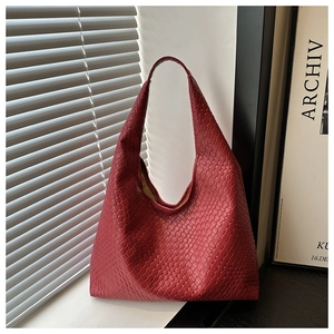 Gros plan sur la texture du sac hobo rouge tressé avec effets d'ombre et de lumière douce