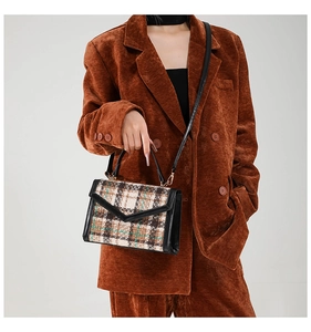 Dettaglio della borsa a tracolla vintage in tweed scozzese con finiture in pelle