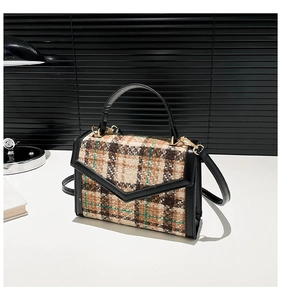 Dettaglio borsa a mano vintage in tweed scozzese con finiture in pelle nera e oro