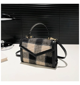 Dettaglio della borsa vintage a quadri con finiture in pelle e chiusura a patta a V