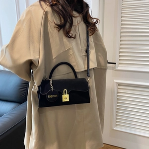 Sac à bandoulière noir de style français avec serrure dorée et pendentif de mode sur trench
