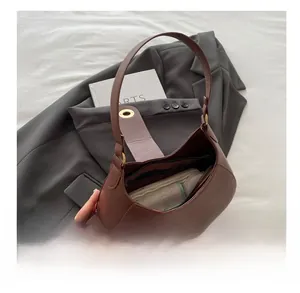 Interior view of brown leather crescent bag showing storage space and zipper pocket