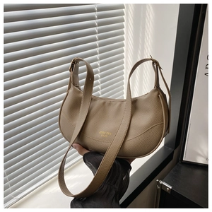 Detail of khaki crescent shoulder bag featuring lychee grain leather and gold logo