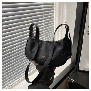 Detail of black pebbled leather hobo bag showing gold logo and metal hardware buckle