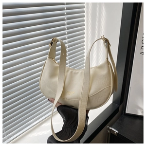 Detail of creamy white crescent bag featuring lychee grain leather and gold hardware