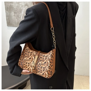 Détail du sac hobo léopard avec chaîne en métal doré et bandoulière en cuir marron