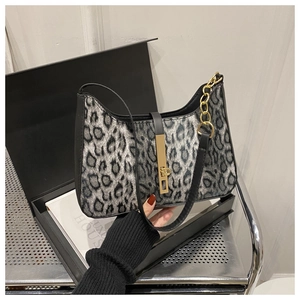 Détail du sac léopard avec fermoir doré métallique et bandoulière noire chic
