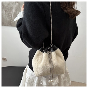 Detail of plush bucket bag with silver chain, pearl charms and black leather trim