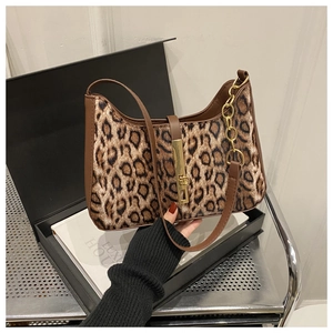 Détail du sac sous le bras à motif léopard avec boucle dorée et bandoulière en cuir