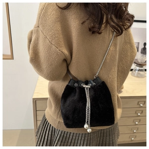 Detail of black faux fur bucket bag with silver chain strap and pearl drawstring accents