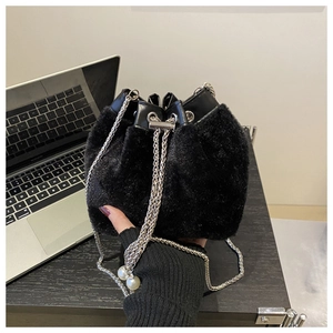 Detail of black plush bucket bag with pearl chain strap and drawstring closure