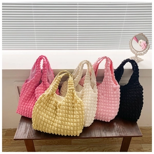 Detailed close-up of bubble textured tote bags in pink, yellow, white, and black colors