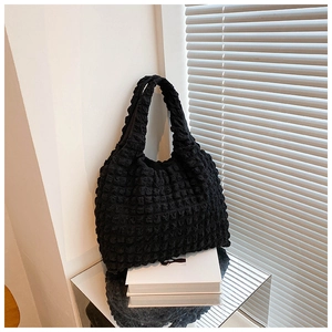 Detail of black popcorn texture tote bag showing pleated 3D fabric and minimalist design