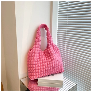 Close-up of pink popcorn textured handbag showing elastic bubble pleated fabric details