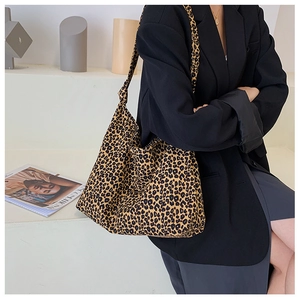 Borsa tote in tela leopardata abbinata a un blazer nero in un ambiente minimalista