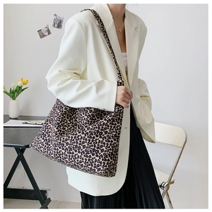 Borsa a tracolla in tela con stampa leopardata indossata da modella su sfondo bianco