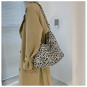 Dettaglio di una grande borsa tote in tela con stampa leopardata indossata da una modella