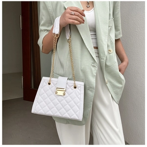 Chic white quilted handbag with gold chain strap styled with a light green blazer outfit