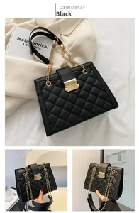 Detail of black quilted shoulder bag with gold metal clasp and elegant chain strap