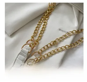 Detail shot of white crocodile pattern leather strap with golden metal chain link