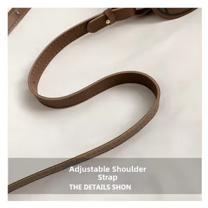 Close-up of the dark brown leather adjustable shoulder strap with pebble grain texture